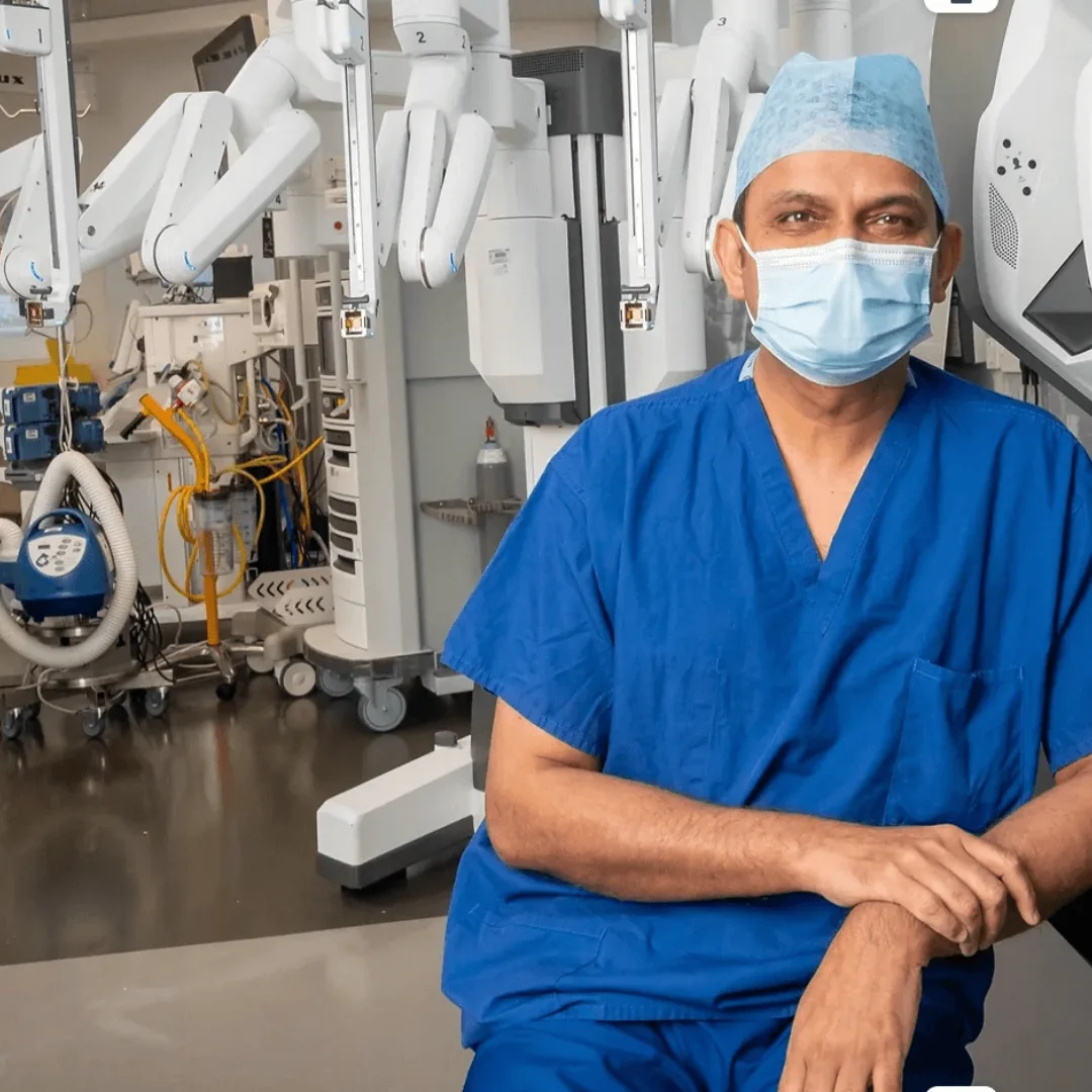 Professor Prokar Dasgupta in theatre beside a surgical robot